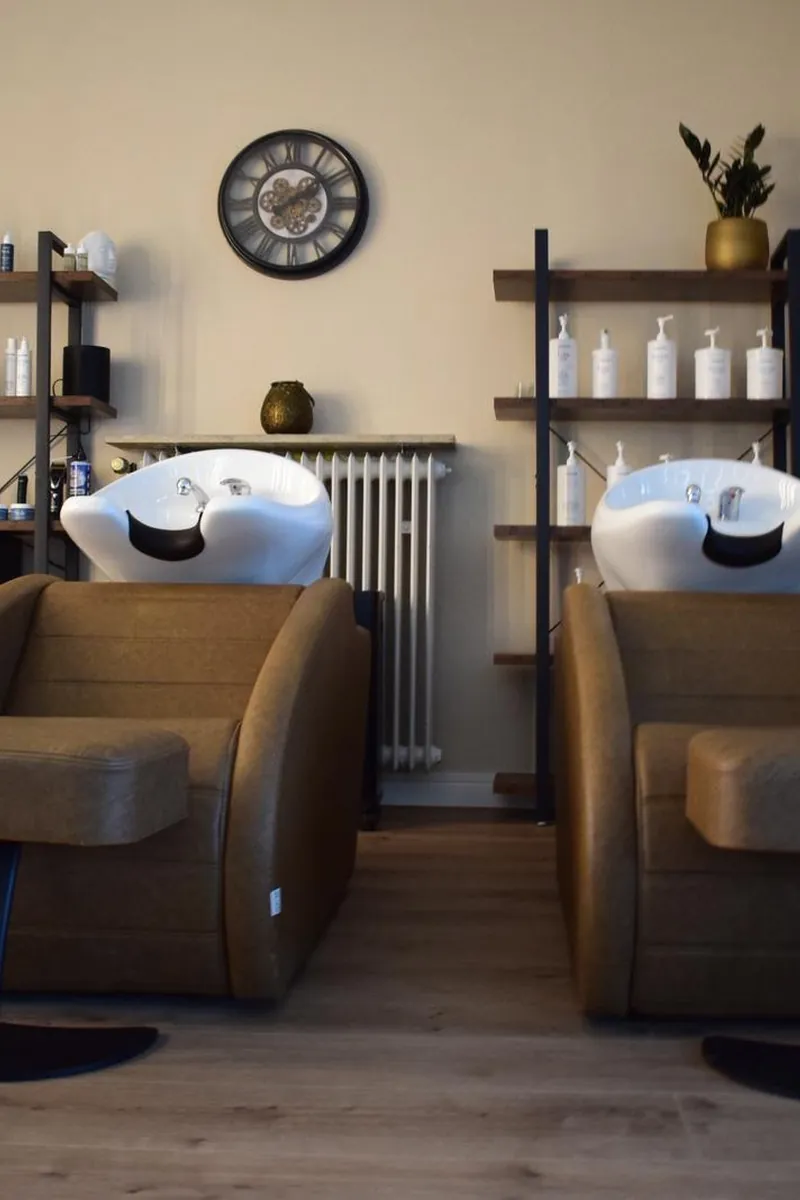 Waschbereich mit Produktregalen im RR Exclusive Salon